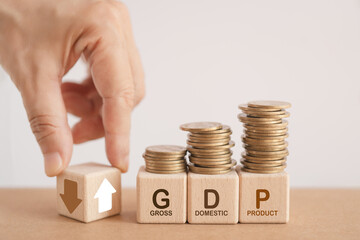 GDP, gross domestic product symbol. Businessman flip cube with up and down arrow and text including...