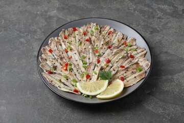Tasty pickled anchovies with spices on grey textured table