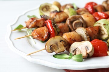 Delicious shish kebabs with vegetables and microgreens on table, closeup
