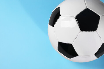 One soccer ball on light blue background, above view with space for text. Sports equipment