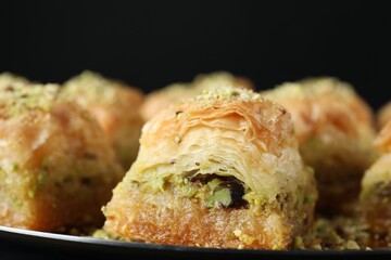 Delicious fresh baklava with chopped nuts on plate, closeup. Eastern sweets
