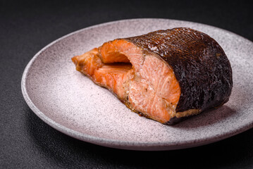 Fresh cooked delicious salmon steak with spices and herbs baked on a grill