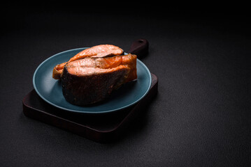 Fresh cooked delicious salmon steak with spices and herbs baked on a grill