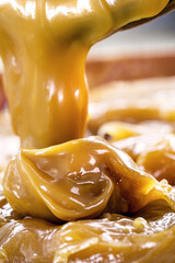 spoon of dulce de leche or homemade vegan pasty milk candy, caramel made with unsweetened coconut...