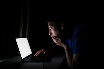 Close up of shocked man looking at laptop at the night time