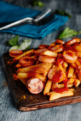 german currywurst and chips on a chopping board