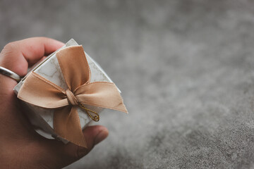 Man hand holding a box of wedding gift for guest, wedding souvenirs