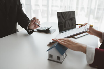 The broker is calculating the buyer's monthly instalment payments, Real estate broker agent...