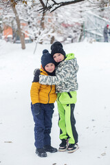 Fototapeta na wymiar Happy children hugging outside in winter. Brother and sister together. Outdoor play.