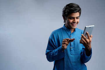 A young Indian men, holding phones and Diwali lamps