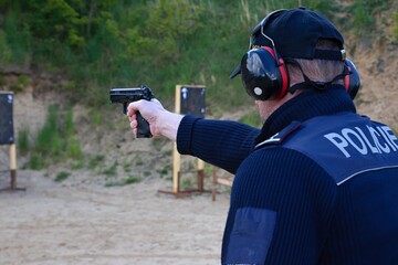 police officers practice shooting a pistol at a target