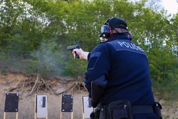 police officers practice shooting a pistol at a target