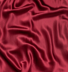 Fototapeta na wymiar Natural magenta red silk fabric with folds texture close up