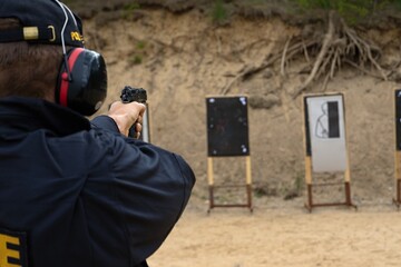 police officers practice shooting a pistol at a target