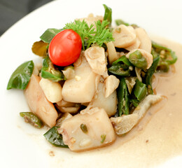 CUMI CABE HIJAU. Spicy stir fry Squid with green pepper, shallot, and garlic. Served on white plate. Selective focus.
