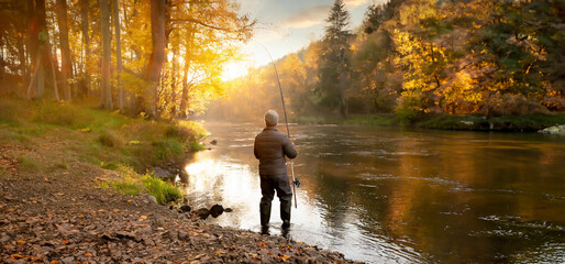 autumn river at sunset and a fisherman