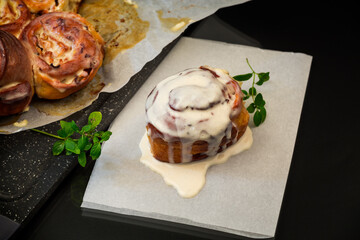cooked baked sweet Cinnabon with cream in baking paper .