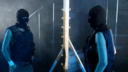 sexy woman in military gown and black balaclava looking at her reflection in mirror, portrait
