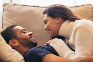 Romantic stock photo of young couple on sofa at home