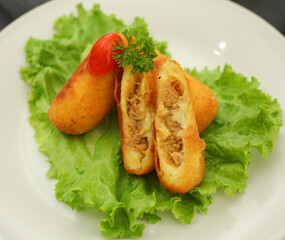 Home made potato and tuna fish croquette. Italian oven baked potato ovals with curry, tuna fish and fresh parsley and tomato. Selective focus.
