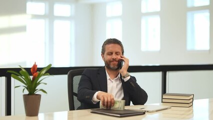 Funny happy business man counting dollars in office. Business man in suit with money dollars. Businessman hold dollars money banknotes. Amazed business man in suit count dollars.