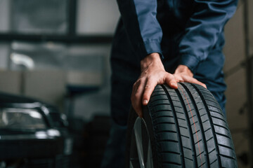 Close up view of man that is moving tire of the car