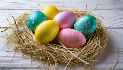 Fototapeta na wymiar colorful easter eggs in the nest of straw on the white wooden background