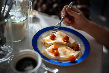 Man having tasty breakfast in restaurant pancakes with jam from apples ranets. Delicious fresh food...