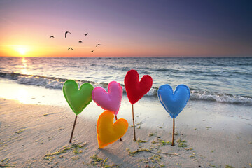 Romantik am Strand mit bunten Herzen - obrazy, fototapety, plakaty