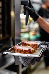 chef hand cooking pork meat in oven on kitchen