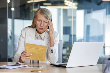 Businesswoman boss received letter mail notification message with bad news, upset and sad senior...