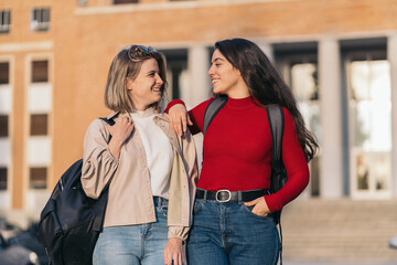 Two student girls portrait in college looking each other. Blonde and brunette