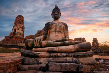 Ancient stone Budha statue in Khmer temple in Ayutthaya, Thailand on sunset - obrazy, fototapety, plakaty