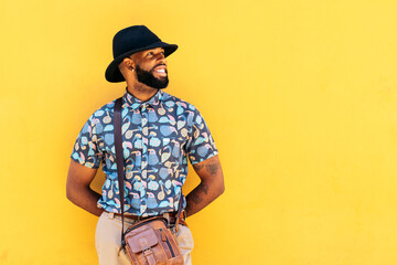 Stylish black man outdoors over yellow background
