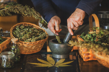 Male Hands Preparing a Medical Cannabis Extract in an Alternative Herb Medicine Store using a Stone...