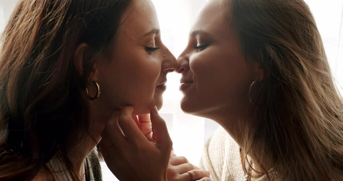 Closeup on female couple kissing tender while spending time together. Two beautiful women in romantic relationship, feeling love and embracing. Closeness concept