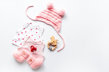 Set of baby girl dress - bodysuit with knitted hat and boots, top view. Kids clothing flat lay