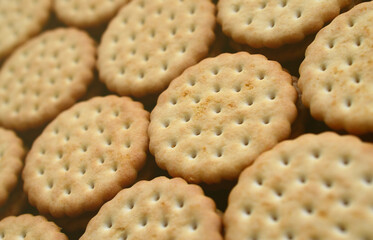 Detailed picture of round sandwich cookies with coconut filling. Background image of a close-up of several treats for tea