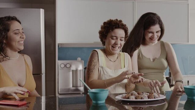 Mulheres jovens na cozinha fazendo brigadeiro, uma sobremesa tradicional brasileira. Cinematico 4k.