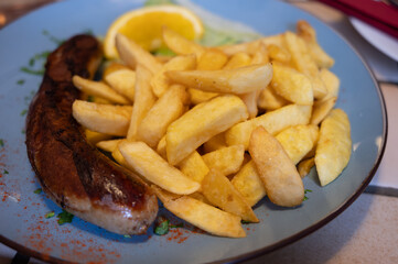 Fried fries potatoes with grilled meat German sausage served in old restaurant in Germany