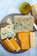 English cheeses collection, mature and coloured cheddar cheese and semi-soft, crumbly old stilton...
