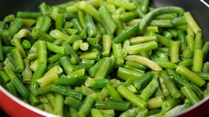 Green beans are being cooked in a pan, close up. Selective focus