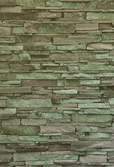Texture of a stone wall from long and rough stones of different sizes and tones