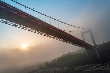 A bridge in Chongqing is shrouded in fog, a tranquil scene that captures the city's mysterious atmosphere. This was taken on a Yangtze River ferry.