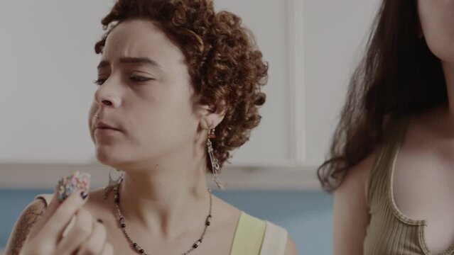 Mulheres jovens na cozinha comendo brigadeiro, um doce tradicional do Brasil. Closeup. Cinematico 4k.