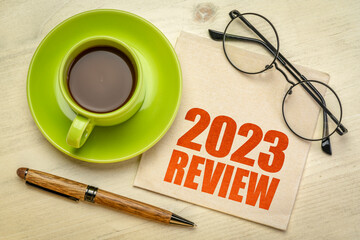 2023 year review text on a napkin with a cup of coffee, end of year business concept - obrazy, fototapety, plakaty