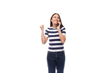 happy young brunette woman with straight hair dressed in a striped t-shirt chatting on the phone