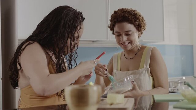 Jovem filmando a amiga enquanto ela cozinha. Cinematico 4k.