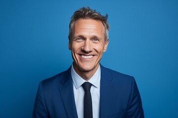Portrait of a Smiling Businessman with Confident Smile on Blue Background