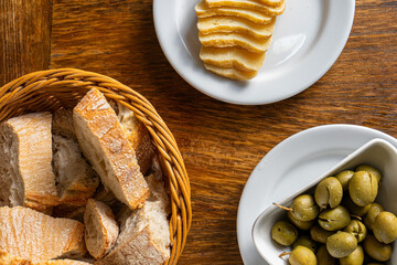 Rustic Alentejo restaurant table showcasing green olives, Alentejo cheese, and traditional bread.